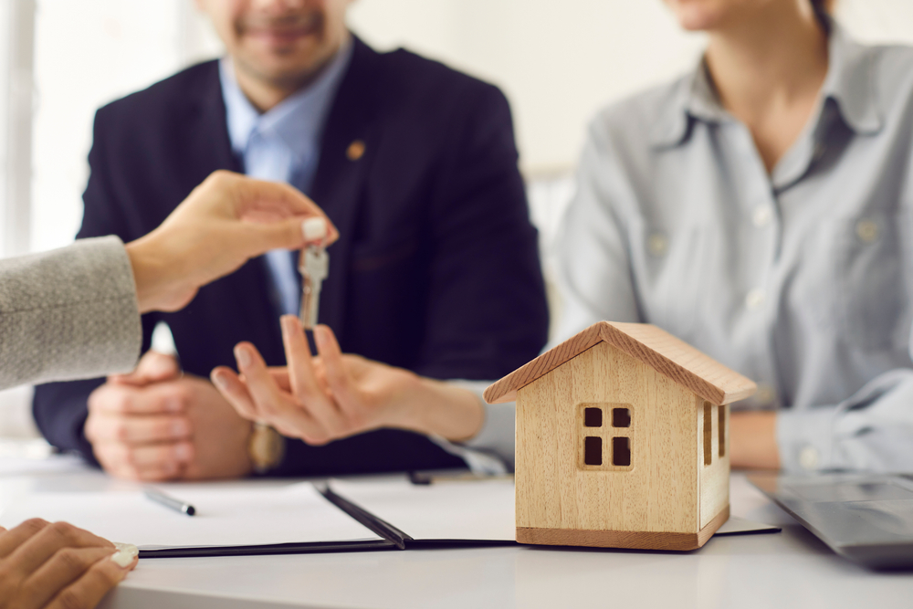 agente inmobiliario entrega llaves clientes